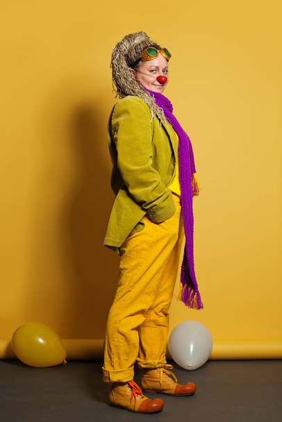 Woman clown on yellow background - Foto, afbeelding