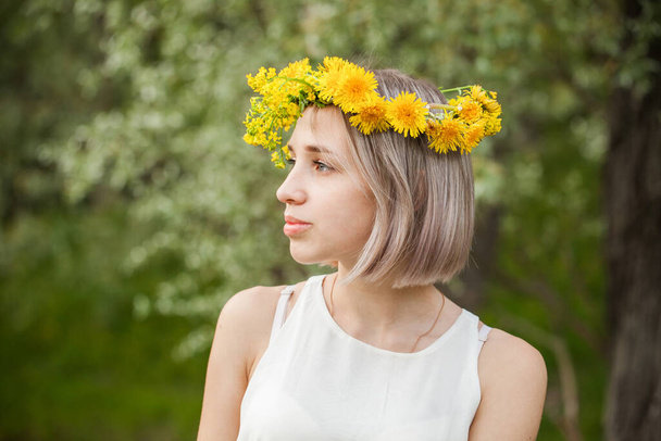 Joven bonita mujer usando flores corona en primavera parque al aire libre
 - Foto, Imagen