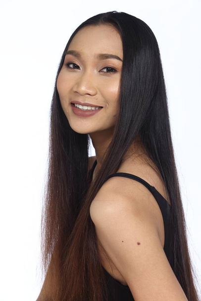 Belle asiatique longue droite cheveux noirs bronzage femme en robe noire mince, maquillage de mode, éclairage studio fond blanc isolé espace de copie
 - Photo, image