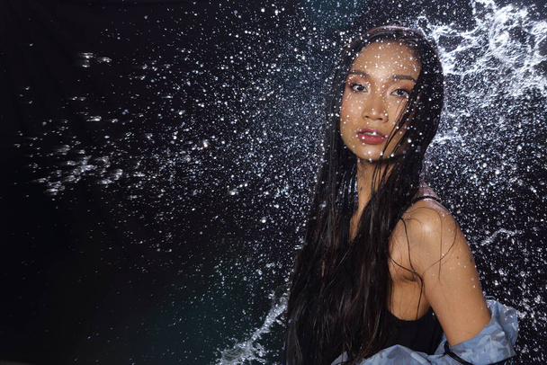 Krásné aktivní fitness asijské opálené žena modrý plášť s vodou Splash přes studio osvětlení černé pozadí kopírovat prostor pro textové logo, bez retuše, koncept vodní festival svěžest energie - Fotografie, Obrázek