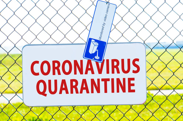 Warning about epidemic quarantine. Coronavirus disease outbreak. nCoV alert sign. Biohazard, not trans-passing. Blue sign handing on a fence. Sign on wire fence. - Fotografie, Obrázek