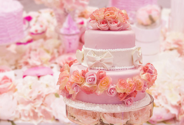 ピンクのウェディングケーキデザートテーブルの上のロマンチックなピンクのテーマに装飾 - 写真・画像