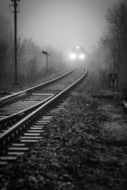 Вантажний потяг, що виходить з туману при наближенні до залізничного вузла, монохромне зображення
 - Фото, зображення