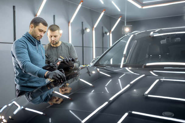 Measuring paint cover thickness of the car body at the service - 写真・画像
