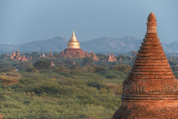 Szcenírozott és lenyűgöző napkelte a mianmari Bagan feletti régészeti övezetben. Bagan egy ősi város és a Világörökség része, melyet az UNESCO hitelesített több ezer történelmi buddhista templommal. - Fotó, kép