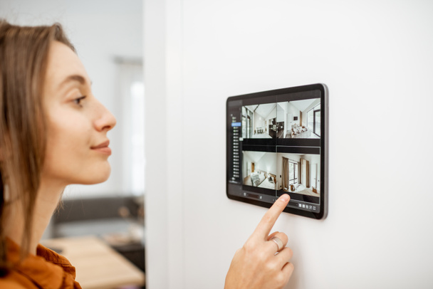 Woman controlling home with video cameras and digital tablet - Photo, Image