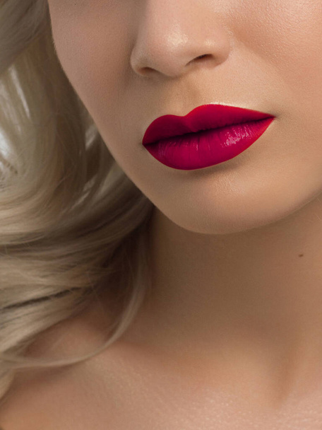 Sexual full lips. Natural gloss of lips and woman's skin. The mouth is closed. Increase in lips, cosmetology. Pink lips and long neck. Gentle pure skin and wavy blonde hair. - Photo, Image