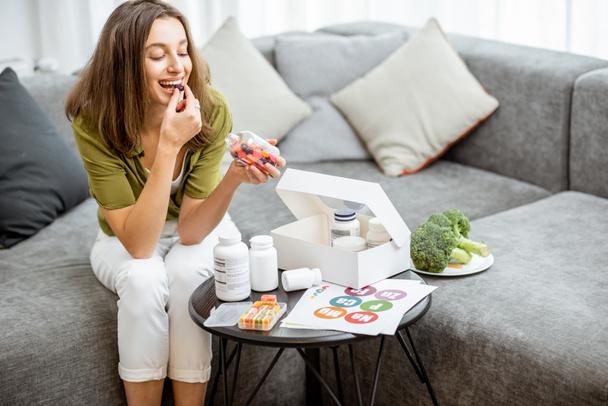 Woman taking vitamins or nutritional supplements - Zdjęcie, obraz