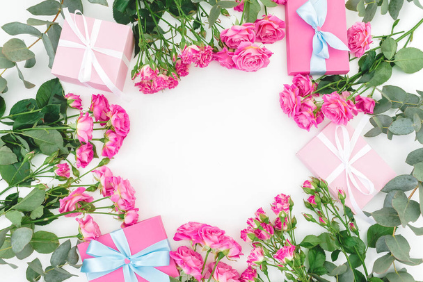 Marco floral de rosas rosadas flores y regalos sobre fondo blanco. Piso tendido, vista superior. Feliz cumpleaños.
 - Foto, Imagen