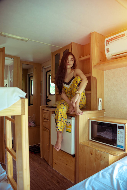 Beautiful young asian woman in a camper van on a summer day - Valokuva, kuva