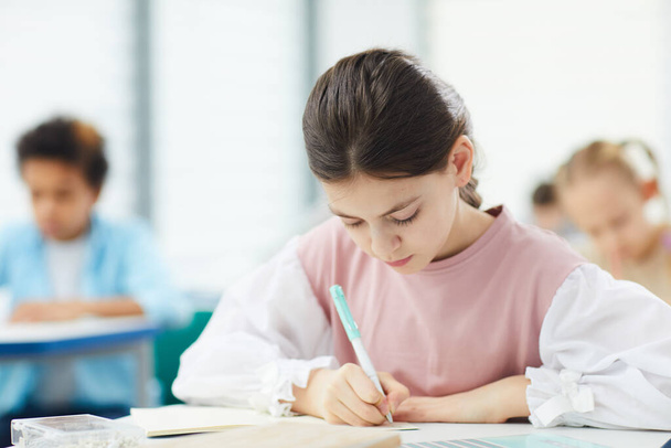 Schoolgirl Writing Essay In Class - Zdjęcie, obraz