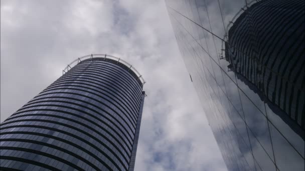 4kのUhd運動時間ビジネス街の建物の経過、青空と雲、移動雲。金融経済、建設業、ビジネスと開発の概念、オフィスタワーの反射 - 映像、動画