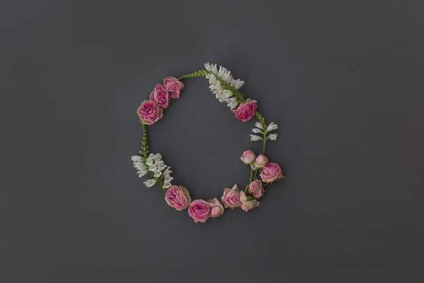 Wreath of roses and white flowers on a gray background. Flowers composition. Minimalist concept for your mockup and project. Layout, flat lay, copy space, top view. - Photo, image