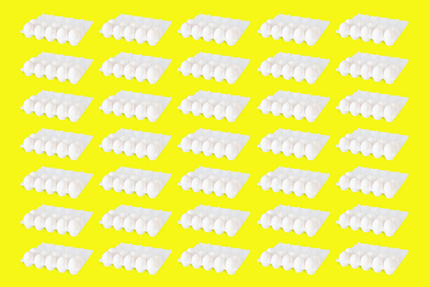 Abstrakti pop art tyyli kuva useita rivejä pakkauksissa kymmenkunta valkoista kuori munia keltainen eristetty tausta. Luonnollinen terveellinen ruoka
. - Valokuva, kuva
