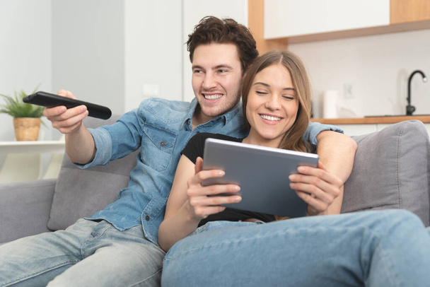 Couple watching TV on sofa. Television, multimedia, leisure concept - Foto, afbeelding
