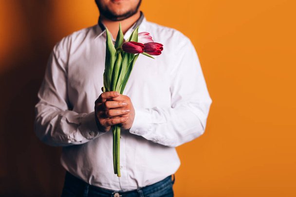 hombre sostiene tulipanes
 - Foto, imagen