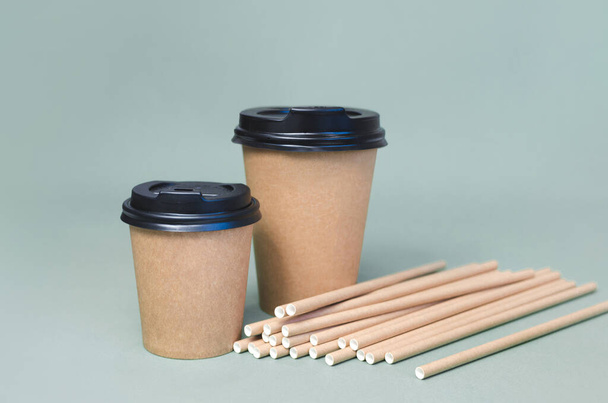 Craft coffee cups with paper straw on gray background. Eco friendly design. Zero waste, plastic free items - Photo, Image
