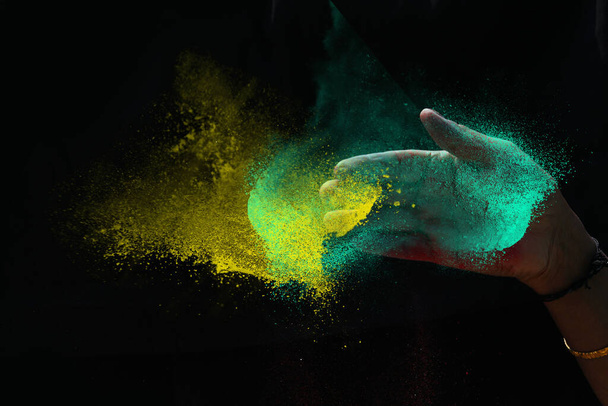 indiana mulher mão colorido holi pó respingo no preto fundos
 - Foto, Imagem