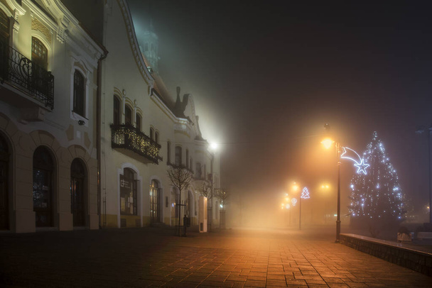 Ciudad en la noche en la niebla con decoración de Navidad
 - Foto, Imagen