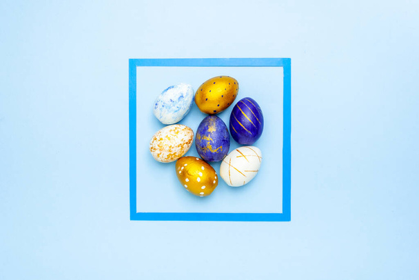 Happy Easter. One easter egg trendy colored classic blue, white and golden on blue background. Copy space. Minimal style. Flat lay, top view - Foto, Bild