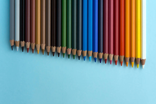 Açık mavi arkaplanda renkli kalemler. Renklere göre sıralanmış kalemler. - Fotoğraf, Görsel