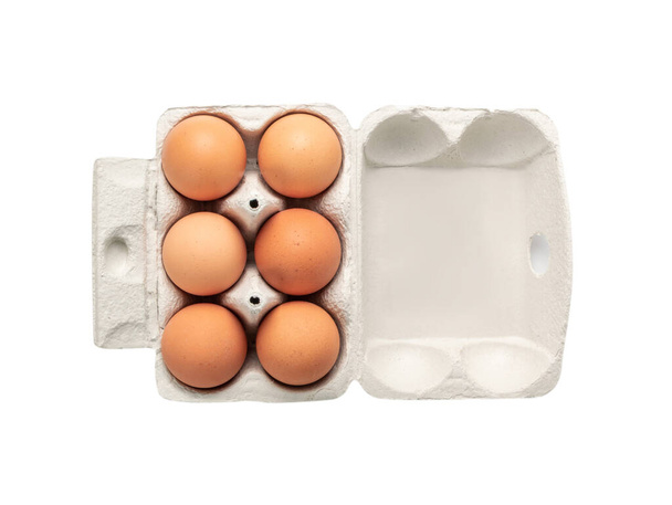 Nyitott tojástartó hat barna tojással, fehér alapon elkülönítve, vágási útvonallal. Friss ökológiai csirke tojás kartondobozban vagy tojástartályokban felülnézet - Fotó, kép