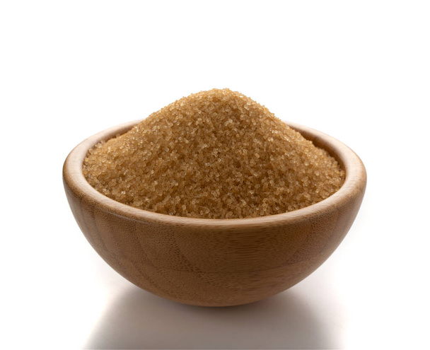 Pile of brown sugar in wood bowl isolated on white background. Raw unrefined cane sugar heap side view - Photo, Image