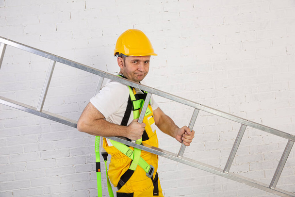 Um construtor profissional com uma escada, compacto e pronto para trabalhar a qualquer momento
. - Foto, Imagem
