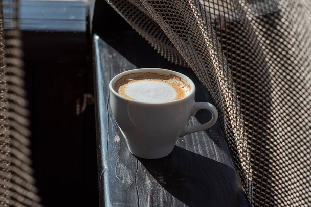 A kávé szelektív fókusz. Fehér csésze cappuccino a természetben. Fehér csésze cappuccino, kávé, reggel, vidámság. - Fotó, kép
