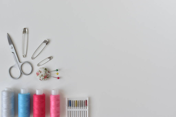 Sewing accessories, pink thread, scissors with pins - Fotó, kép