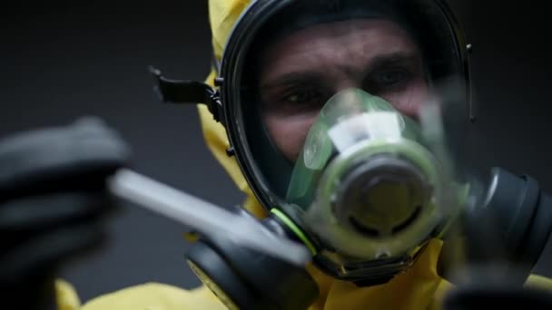 Il lavoratore caucasico del laboratorio inietta con attenzione il liquido giallo nella provetta mentre osserva le reazioni chimiche che si verificano
.  - Filmati, video