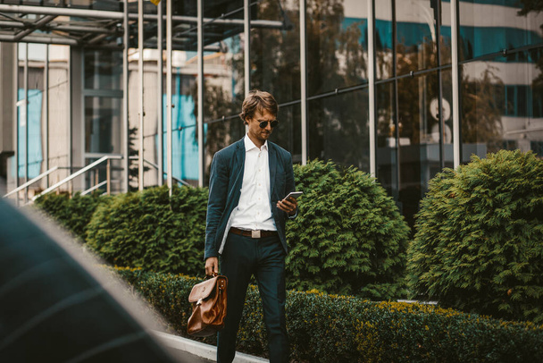Young businessman walking on a street by business center - Photo, image