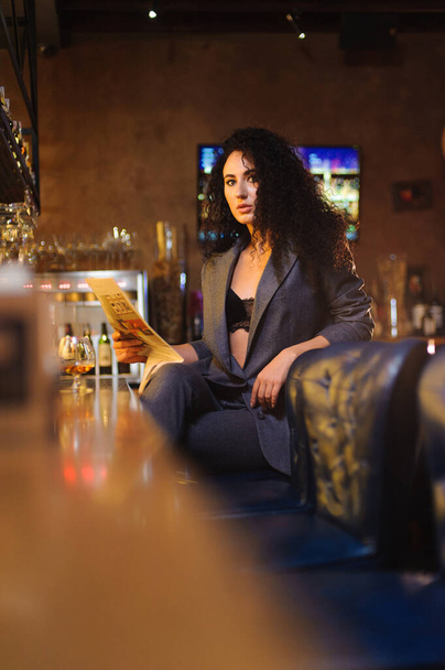 Elegante dama en un traje de negocios, en un restaurante en un bar solo
 - Foto, Imagen