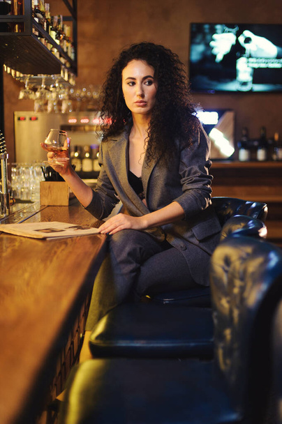 Elegáns hölgy egy üzleti öltönyben, egy étteremben egy bárban egyedül. - Fotó, kép