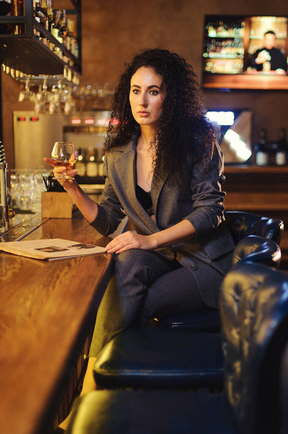 Elegante dama en un traje de negocios, en un restaurante en un bar solo
 - Foto, Imagen