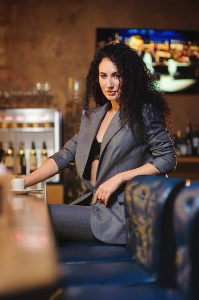 Элегантная леди в деловом костюме, в ресторане у барной стойки
 - Фото, изображение