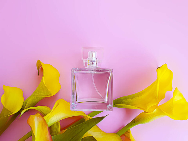 parfum fles calla bloem op een gekleurde achtergrond - Foto, afbeelding