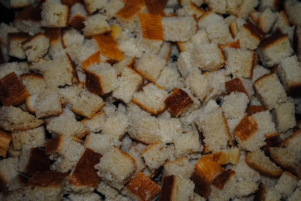 Piazze di pane. Un mazzo di briciole di pane su una teglia da forno prima della cottura. Fette biscottate. Mandrini duri. Cracker
 - Foto, immagini