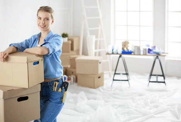 Young woman moving house to new home holding cardboard boxes - Foto, Imagen
