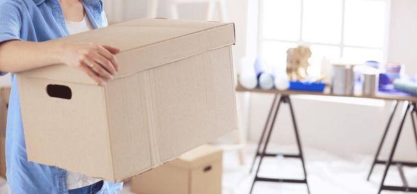 Young woman moving house to new home holding cardboard boxes - Foto, immagini
