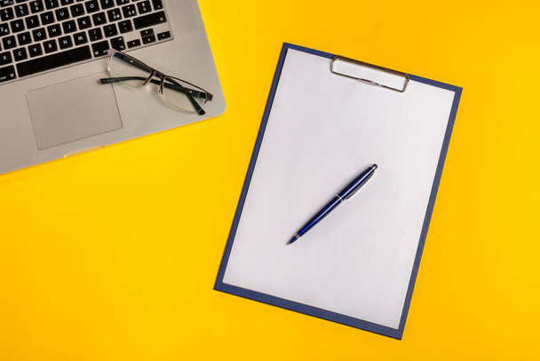 Disposizione piatta. Computer su sfondo giallo con foglio di carta, penna e bicchieri. Idea di business concept. Copia spazio
. - Foto, immagini