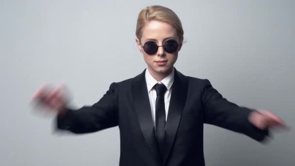 zakenvrouw in een klassiek zakenpak en zonnebril toon verbod symbool - Video