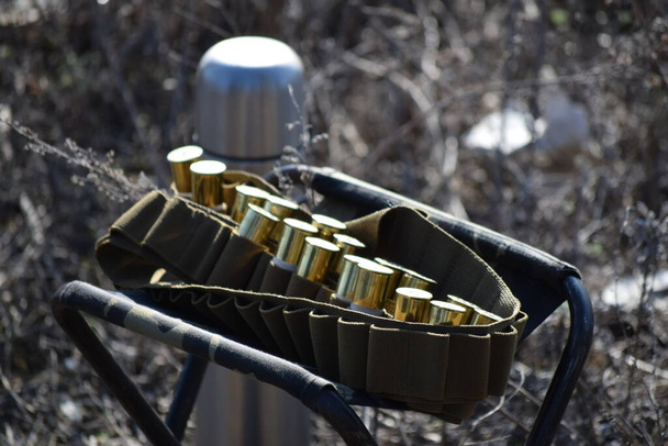 Thermos and bandolier with 12 gauge shotgun cartridges - 写真・画像