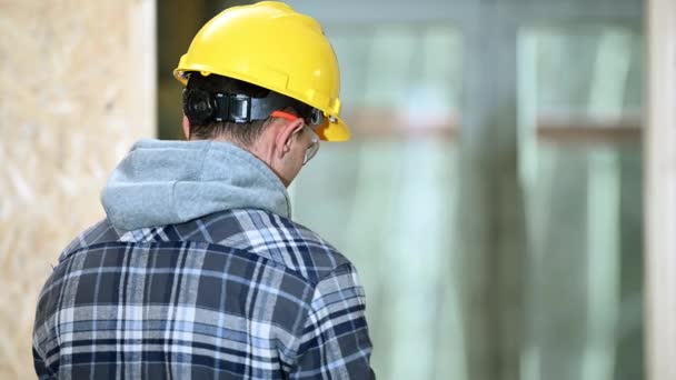 Trabalhador da construção masculina se preparando para seu turno garante a segurança pessoal, colocando capacete e luvas
.  - Filmagem, Vídeo
