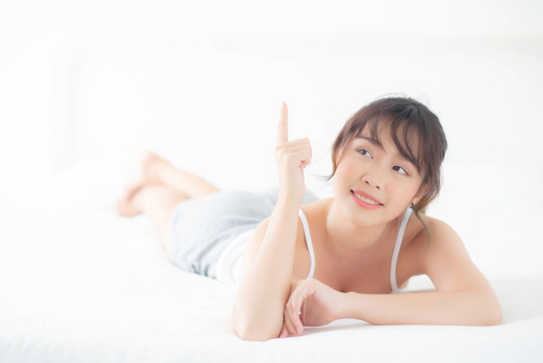 Porträt schöne junge asiatische Frau lächeln aufwachen gesund und Wellness am Morgen, Schönheit asiatische Mädchen liegen und zeigen etwas Hautpflege und Make-up Kosmetik mit glücklich, Lifestyle und Relax-Konzept. - Foto, Bild