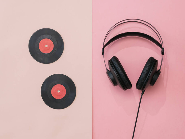 Two vinyl discs and headphones on a pink background. - Fotó, kép
