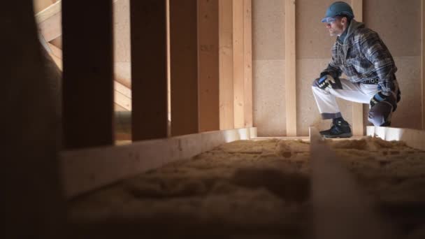 El trabajador de la construcción investiga el ático para determinar la cantidad de trabajo y materiales necesarios para terminar el trabajo
.  - Metraje, vídeo