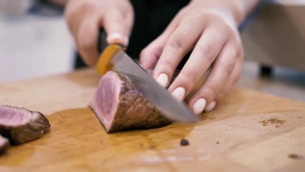 Dívka kuchař krájí maso steak na plátky - Záběry, video