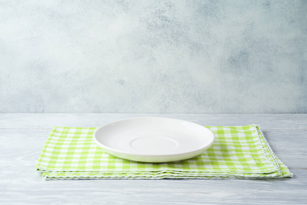 Empty plate with tablecloth on wooden table. Spring and easter mock up for design - Foto, afbeelding