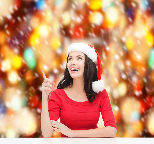 Woman in santa helper hat pointing to something - Photo, image